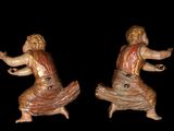 two figurines of a woman dancing on a black background