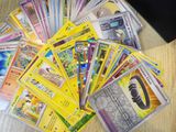 a lot of pokemon cards on a table next to a laptop