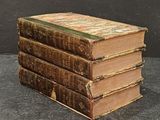 several old books stacked on top of each other on a table