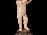 statue of a baby on a pedestal with a black background