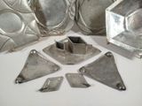 several pieces of silver metal are arranged on a white surface