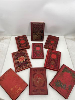 un tas de livres rouges posés sur une table blanche