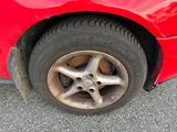 a close up of a red car with a flat tire