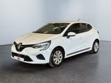 Une voiture blanche est garée dans une pièce au sol noir