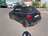 a small black car that is parked in a parking lot