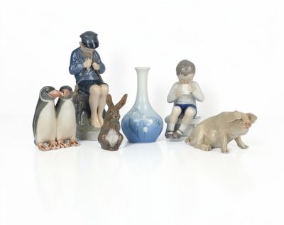 several figurines of people and animals sitting on a white surface
