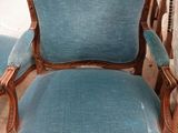 une image représentant une chaise bleue placée dans une pièce, à côté d'une table