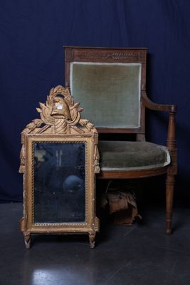 une chaise sur laquelle est posé un miroir, à côté d'une autre chaise