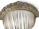 a gold comb with flowers on it on a white background