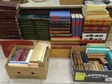 several boxes of books are stacked on a table in a room