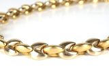 a close up of a gold chain bracelet on a white surface