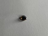 a close up of a small black diamond on a white surface
