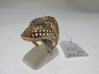 gros plan d'une bague en or avec des diamants sur une surface blanche