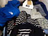 a pile of clothes and a hat on a bed