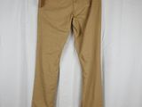 a pair of tan pants hanging on a hanger in front of a white curtain