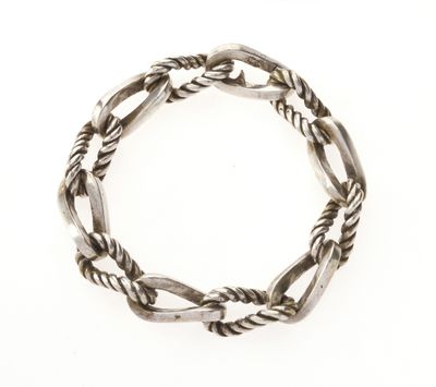 gros plan d'un bracelet en argent sur fond blanc