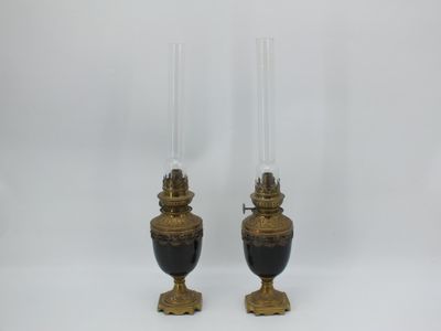 deux vases noirs et dorés avec des bougies, sur fond blanc