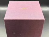 a pink box with a gold logo on it sitting on a table