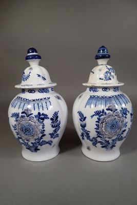 two blue and white vases with lids on a gray surface