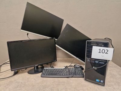 trois écrans d'ordinateur et un clavier posés sur une table