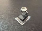 a metal object on a leather surface with a ring on top of it