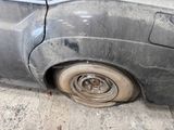 a car that has a flat tire on the side of the road