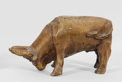 une vache en bois posée sur une surface blanche