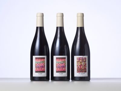 trois bouteilles de vin posées sur une table l'une à côté de l'autre