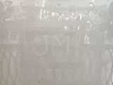 a close up of a glass vase with a monogram on it