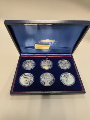 a set of six silver coins in a blue box