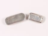 pair of silver plated rectangular shaped metal objects on a white surface
