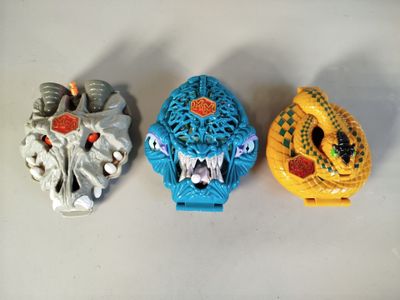 trois figurines de formes et de tailles différentes posées sur une table