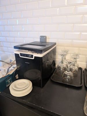 un plan de travail noir avec un micro-ondes et un plateau de beignets