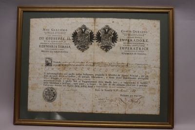 an old document is hanging on a wall next to a framed picture