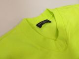 a close up of a neon yellow t - shirt on a white surface