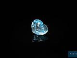 une topaze bleue en forme de cœur sertie de diamants sur un fond noir