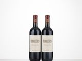 two bottles of wine sitting on top of a table next to each other