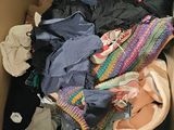 a cardboard box filled with clothes and a pair of shoes