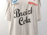Le t-shirt est blanc et comporte une inscription noire.