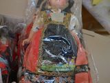 two dolls sitting in a box on a table