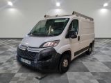 une camionnette blanche garée sur un sol en damier