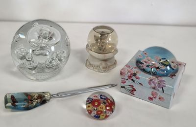 trois objets en verre posés sur une table, avec une cuillère et un repose-cuillère