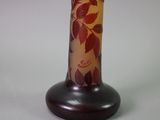 a glass vase with a red and yellow design on it