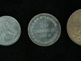 four different types of coins in a row on a black background