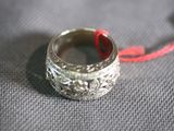 a silver ring with a red string attached to it