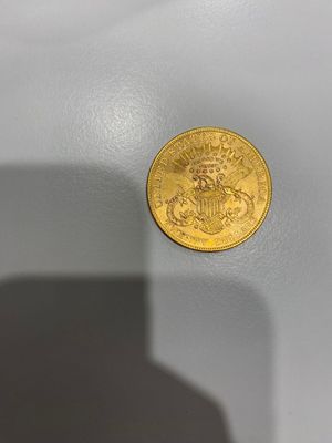gros plan d'une pièce d'or sur une surface blanche