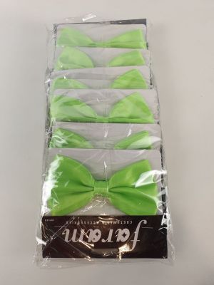 six nœuds papillon vert citron dans des sachets en cellophane, posés sur une table blanche