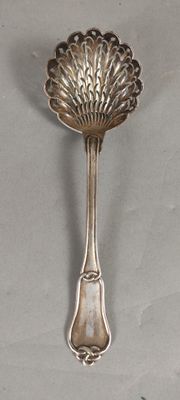 a silver spoon with a leaf on it on a table