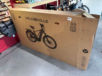 un carton sur lequel est représenté un vélo, dans un garage