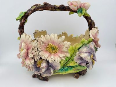 un petit panier orné de fleurs, posé sur une surface blanche